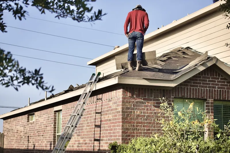 Professional roofer working on a residential roof in Saxton